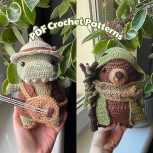 Puede incluir: Dos juguetes amigurumi de crochet, un lagarto verde y marrón que sostiene una guitarra y un oso marrón que lleva una capa verde con capucha. Los juguetes sostienen un palo en sus manos. La imagen incluye el texto "PDF Crochet Patterns".