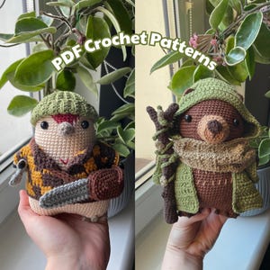 May include: Two crocheted amigurumi toys. The first is a brown bear wearing a green hooded cloak and a brown scarf. The second is a white bird wearing a plaid shirt and holding a chainsaw. The text "PDF Crochet Patterns" is visible in the image.