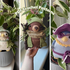 May include: Three crocheted amigurumi toys: a brown bear wearing a green hooded jacket and scarf, a light blue bird wearing a purple pirate hat, and a beige owl wearing a green hat and cape. The text "PDF Crochet Patterns" is visible in the image.