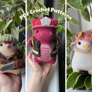 Może przedstawiać: Trzy pluszowe zabawki amigurumi: czerwony i czarny smok strażak, brązowy i żółty ptak drwal oraz biały i różowy pingwin w okularach. Zabawki trzymają wszystkie rekwizyty i są wyświetlane na tle zielonej rośliny. Tekst "PDF Crochet Patterns" jest wyświetlany u góry obrazu.