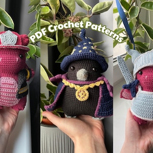 May include: Three crocheted dragon figures dressed as a firefighter, wizard, and knight. The firefighter dragon is red with a black jacket and helmet. The wizard dragon is black with a blue hat and cape. The knight dragon is red with a grey helmet and armour. Text reads "PDF Crochet Patterns".