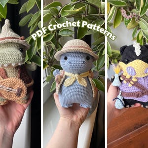 Può includere: Tre bambole di dinosauro all'uncinetto in vari outfit. Uno è verde con cappello e banjo, un altro è blu con cappello e sciarpa, e il terzo è nero e viola con cappello e pozione. Il testo "PDF Crochet Patterns" è sopra le bambole.
