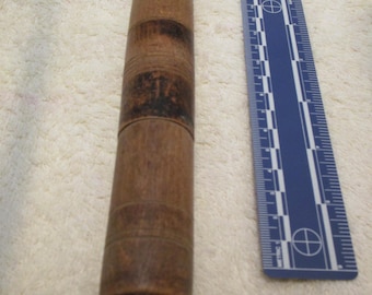 May include: A wooden rolling pin with a dark brown finish and a slightly textured surface. The rolling pin is approximately 10 inches long.