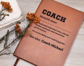 May include: A brown leather journal with the word "COACH" embossed on the front. The journal has a definition of the word "coach" and the text "See also: Coach Michael".