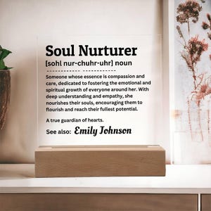 May include: A white acrylic sign with black text defining the word "Soul Nurturer" and its meaning. The sign also includes the name "Emily Johnson" and the phrase "See also:".