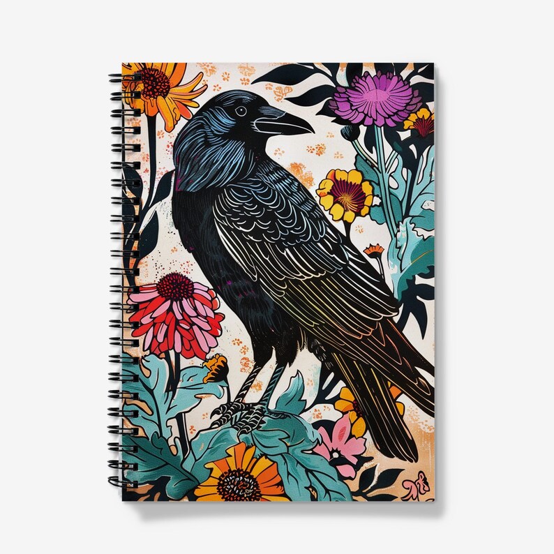 May include: Spiral-bound notebook featuring a detailed illustration of a black raven perched amidst colorful flowers. The artwork includes vibrant hues of orange, pink, purple, and teal, set against a cream-colored background. The raven's feathers are intricately designed.