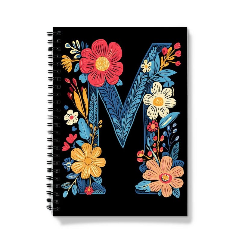 Pode incluir: Um caderno espiral preto com um design floral que apresenta a letra "M" em azul. As flores s&atilde;o vermelhas, amarelas, laranja e brancas.
