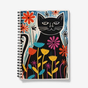 Op de afbeelding: Een zwarte kat met een witte glimlach zit in een veld met kleurrijke bloemen. De bloemen zijn geel, roze, rood, blauw en groen. De achtergrond is een blauw en wit patroon.