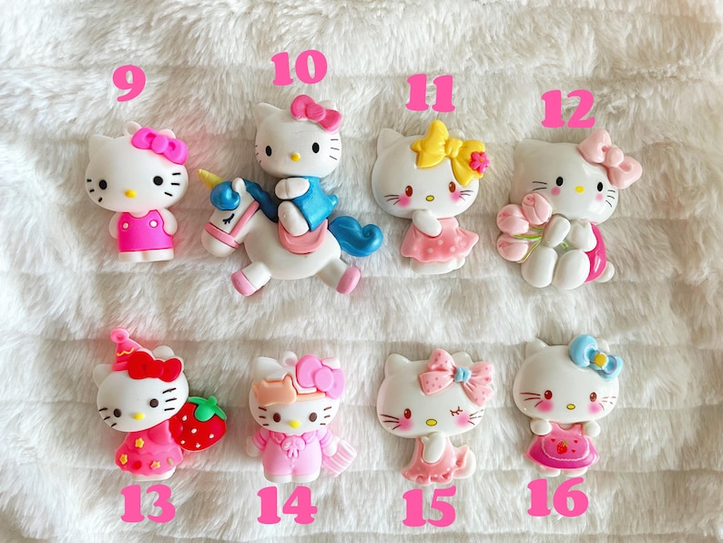 May include: Set of 10 Hello Kitty charms, featuring Hello Kitty in various poses and outfits, including riding a unicorn, holding flowers, and wearing a party hat. The charms are made of plastic and are approximately 2.5 cm in size.