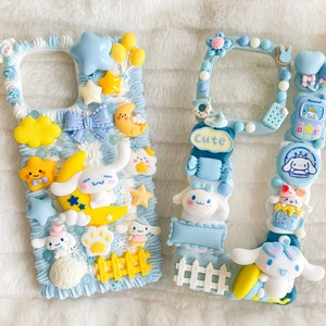 May include: Two white phone cases decorated with pastel blue, yellow, and pink 3D embellishments. The cases feature cartoon characters, hearts, stars, and the word "Cute".