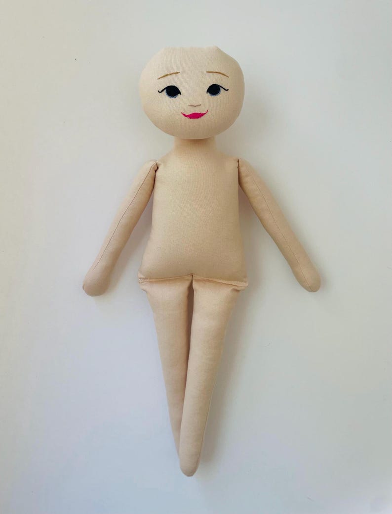 May include: A handmade doll with a light beige fabric body. The doll has a round head with embroidered black eyes, arched eyebrows, and a red smiling mouth. The arms and legs are long and slender, and the doll is posed with arms outstretched.