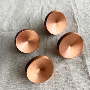 May include: A white ceramic mug with a black handle and the text "But First, Coffee" in a black, bold font. The mug is on a white surface.