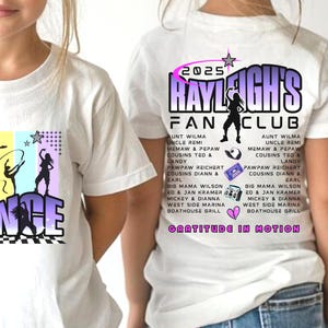 May include: White t-shirts with a colorful graphic design. One shirt features the word "DANCE" with silhouettes of dancers. The other shirt displays "2025 RAYLEIGH'S FAN CLUB" with a dancer silhouette and a list of names.