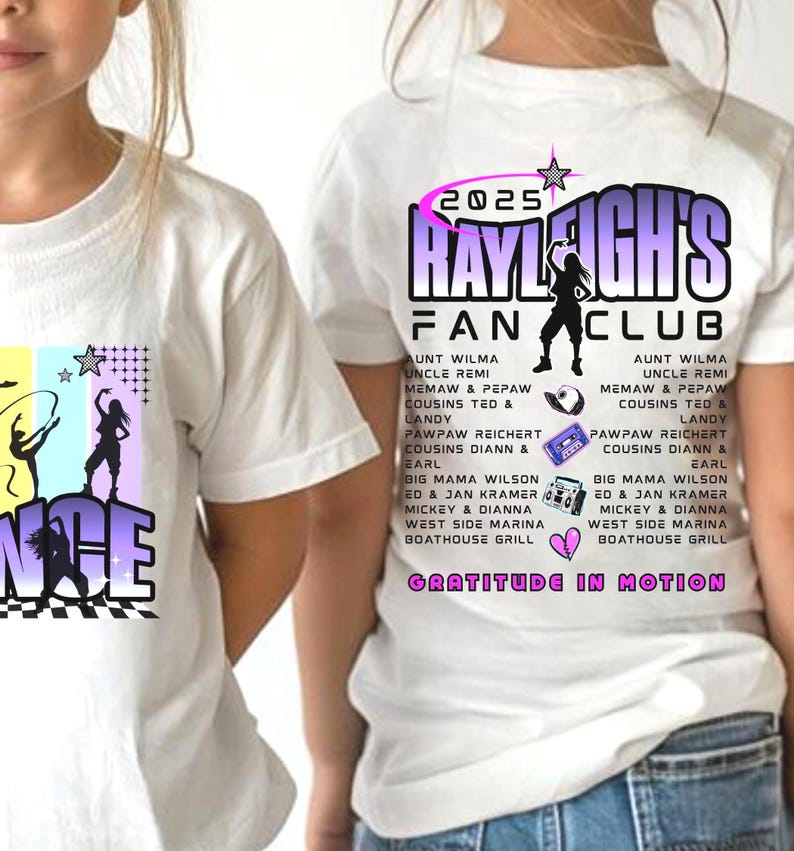 May include: White t-shirts with a colorful graphic design. One shirt features the word "DANCE" with silhouettes of dancers. The other shirt displays "2025 RAYLEIGH'S FAN CLUB" with a dancer silhouette and a list of names.