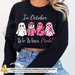 May include: Black sweatshirt featuring the text "In October We Wear Pink!" and a graphic of four ghosts. The ghosts are white, pink, and pink and white checkered, each holding a baseball, wearing a baseball cap, holding a bat, and wearing a pink ribbon.