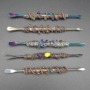 May include: Five different metal tools with decorative wire wrapping and colorful beads. The tools have a flat, rounded tip and are used for dabbing.