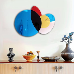 Könnte beinhalten: Abstrakte Wandkunst mit überlappenden Kreisen in Blautönen, Schwarz, Gelb, Rot und Weiß. Die Kreise sind in einem modernen, geometrischen Design angeordnet.