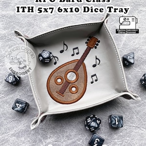 May include: A gray felt dice tray with a brown embroidered lute and musical notes. The tray is 5x7 inches and 6x10 inches. The tray is designed for role-playing games and includes the text "requires snaptabs".