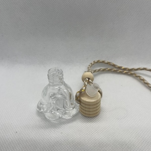 May include: A clear glass bottle shaped like a rose with a wooden diffuser and a string for hanging. The bottle is empty and ready to be filled with essential oils or fragrance.