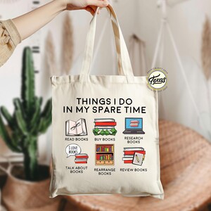 Pu&ograve; includere: Una borsa tote in tela bianca con il testo "THINGS I DO IN MY SPARE TIME" stampato su di essa. La borsa presenta sei illustrazioni di libri e attivit&agrave; legate ai libri, tra cui leggere, acquistare, ricercare, parlare di, riorganizzare e rivedere libri.