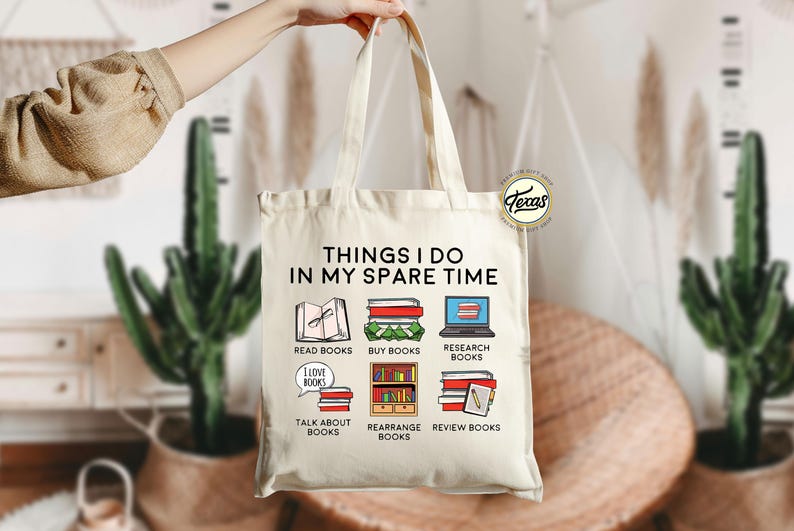 Pu&ograve; includere: Una borsa tote in tela bianca con il testo "THINGS I DO IN MY SPARE TIME" stampato su di essa. La borsa presenta sei illustrazioni di libri e attivit&agrave; legate ai libri, tra cui leggere, acquistare, ricercare, parlare di, riorganizzare e rivedere libri.
