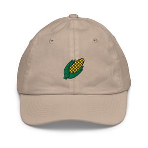May include: A beige baseball cap with an embroidered yellow corn cob with green leaves.