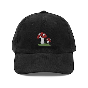 May include: Black corduroy baseball cap with an embroidered design of two red and white mushrooms.