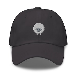 Puede incluir: Una gorra de béisbol negra con un diseño de oveja blanca bordada.