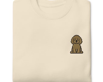 May include: Cream-colored sweatshirt with a small embroidered brown poodle design on the chest. The sweatshirt has a crew neck and a relaxed fit, suitable for casual wear. The poodle is depicted in a seated position.