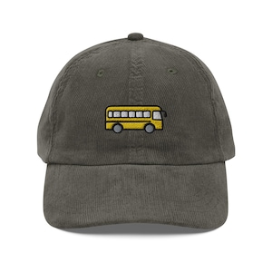 May include: A dark green corduroy baseball cap with an embroidered yellow school bus on the front.