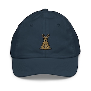 May include: A navy blue baseball cap with an embroidered brown kangaroo on the front.