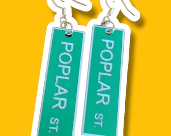 May include: A pair of green and white earrings with the text "POPLAR ST." on each earring.