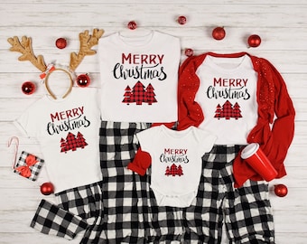 May include: A family matching Christmas pajama set with a white background and red and black buffalo plaid pants. The shirts feature the text "Merry Christmas" with a red and black buffalo plaid Christmas tree design.