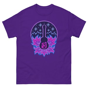 May include: A purple t-shirt featuring a guitar graphic. The graphic includes a black guitar silhouette, snowflakes, and stylized leaves in shades of pink and blue. The guitar has the letters "SJ" in a stylized font.