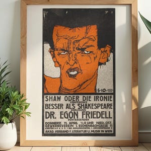 May include: Vintage newspaper poster in a wooden frame. The poster has an orange and black illustration of a man's face with German text. The text includes "SHAW ODER DIE IRONIE" and "DR. EGON FRIEDELL". The words "DIGITAL DOWNLOAD" are at the bottom of the poster.