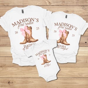 May include: White t-shirts and a onesie with a rodeo theme. Each shirt features the text "MADISON'S first rodeo" with a pair of brown cowboy boots and a pink bow. The onesie reads "I AM the cowgirl".