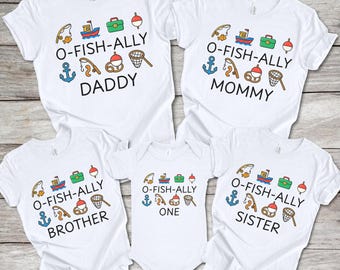 May include: White family matching t-shirts and a onesie with a fishing theme. Each shirt has the text "O-Fish-Ally" followed by "Daddy", "Mommy", "Brother", and "Sister". The onesie says "One". Each shirt has fishing-related graphics.