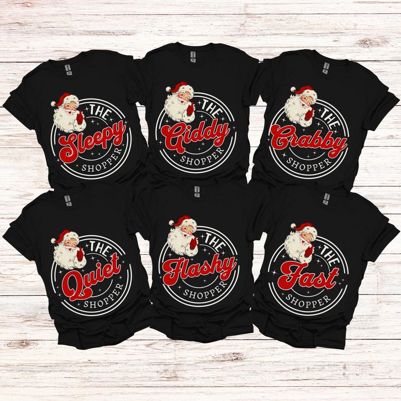 May include: Six black t-shirts with a white circle design featuring a cartoon Santa Claus and text. The text on the shirts reads "The Sleepy Shopper", "The Giddy Shopper", "The Crabby Shopper", "The Quiet Shopper", "The Flashy Shopper", and "The Fast Shopper".