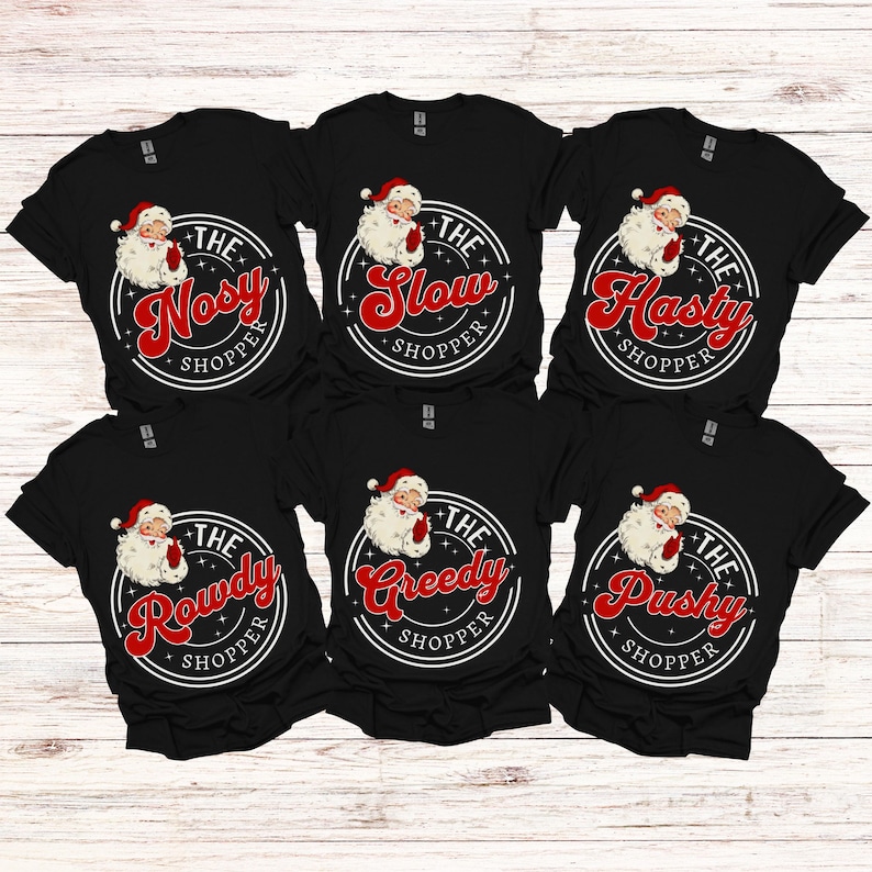 May include: Six black t-shirts with a white circle and red text that says "The [adjective] Shopper" with a cartoon Santa Claus inside the circle. The adjectives are "Nosey", "Slow", "Hasty", "Rowdy", "Greedy", and "Pushy".