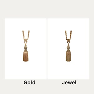 May include: Two curtain tiebacks with tassels. The tieback on the left is gold and the tieback on the right is jewel toned.