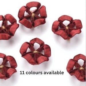 Peut inclure: Six fleurs en tissu rouge avec un centre doré. 11 couleurs disponibles.