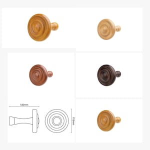 Puede incluir: Cuatro ganchos de pared de madera en diferentes colores y acabados. Los ganchos tienen forma de hongo con una parte superior redonda y un tallo corto. Los ganchos miden 140 mm de ancho y 110 mm de alto.