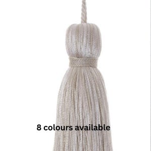 May include: A close-up of a cream-colored tassel with a knotted top. The tassel is made of soft, fluffy fibers and has a simple, elegant design. 8 colours available.