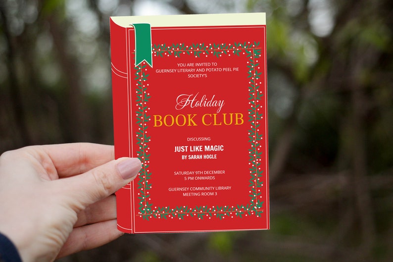 Op de afbeelding: Een rode uitnodiging voor een Holiday Book Club, met de tekst "Holiday Book Club" en details over een discussie over "Just Like Magic" van Sarah Hogle. De uitnodiging heeft een groen lint en een decoratieve rand.