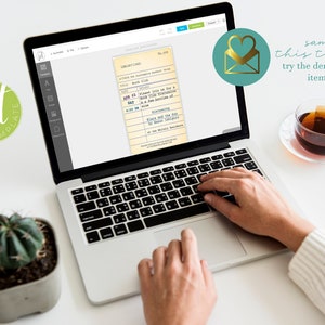May include: A laptop screen shows a vintage library card template. A cup of tea and a small succulent plant sit on a white surface. The text "sample this template try the demo link in the item details" is visible.
