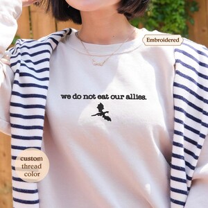 a woman wearing a t - shirt that says, we do not eat our all