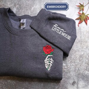 a t - shirt with a rose embroidered on it