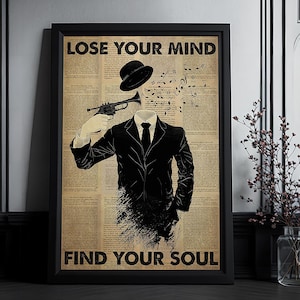 May include: Black framed art print with the text "LOSE YOUR MIND" and "FIND YOUR SOUL". The artwork depicts a man in a suit holding a trumpet to his head, with musical notes and a hat replacing his head.