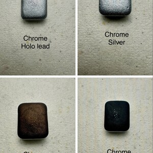 Puede incluir: Cuatro peque&ntilde;os contenedores cuadrados con diferentes acabados cromados: cromo holo lead, cromo plateado, cromo marr&oacute;n y cromo negro.