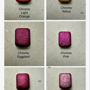 Puede incluir: Seis peque&ntilde;os recipientes cuadrados de pintura cromada met&aacute;lica en los colores naranja claro, amarillo, berenjena, rosa, rosa y oro rosa.